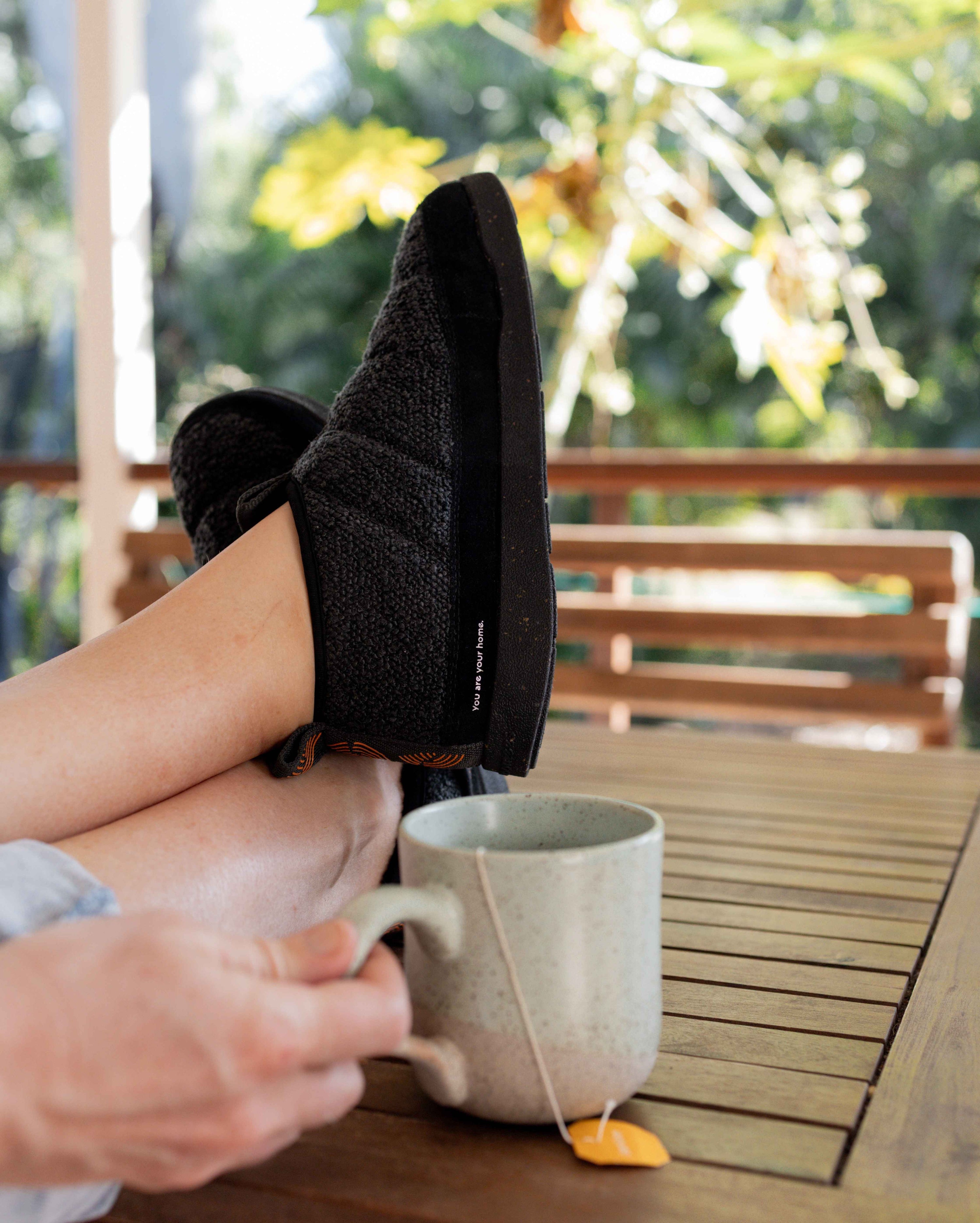Person-relaxing-in-a-pair-of-black-slippers